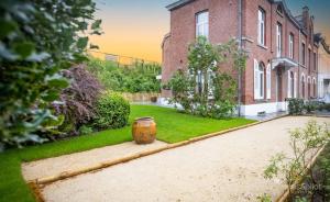una casa de ladrillo con un barril en el patio en 5 bedrooms house with city view jacuzzi and enclosed garden at Spa, en Spa