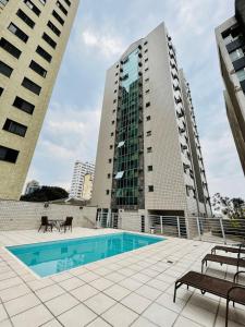 uma piscina em frente a dois edifícios altos em LK Barro Preto 9 em Belo Horizonte