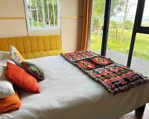 a bed with a blanket on it next to a window at The Cabin in the Woods in Dublin