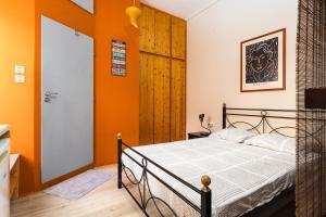 イエラペトラにあるHomy studioのオレンジ色の壁のベッドルーム1室(ベッド1台付)