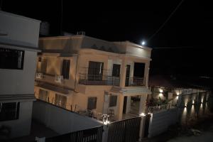 a large building with a balcony at night at Kookee Villa in Hātgarh