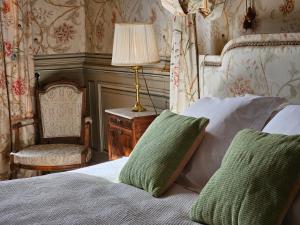 CraonにあるChâteau de Craonのベッドルーム1室(ランプと椅子付きのベッド1台付)