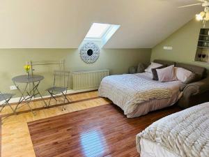 a bedroom with two beds and a table and a window at Quay Lane Studio Apartment in Ballina