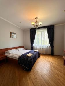 a bedroom with a bed and a chandelier at База відпочинку ШИПОВЕЦЬ in Poroškov