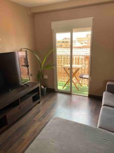 sala de estar con TV de pantalla plana y mesa en Appartement Cosy Quartier Calme Proche Valence en Aldaia