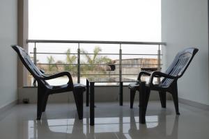duas cadeiras e uma mesa de vidro em frente a uma janela em Kookee Villa em Hātgarh