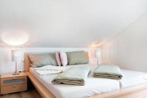a white bed with two pillows on top of it at Ferienwohnung In Der Weinig in Sasbach am Kaiserstuhl