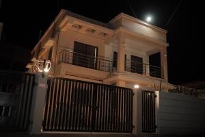 uma casa branca com um portão à noite em Kookee Villa em Hātgarh