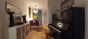 uma sala de estar com um piano e uma sala de estar com uma mesa em Zielona Wiolinowa em Varsóvia