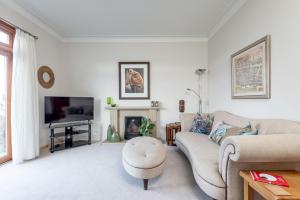 sala de estar con sofá y TV en Livingstone Lodge, en St Andrews