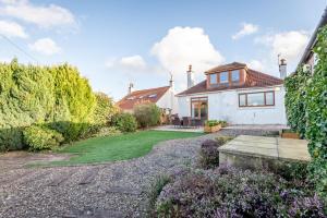 a house with a garden and a driveway at Livingstone Lodge in St Andrews