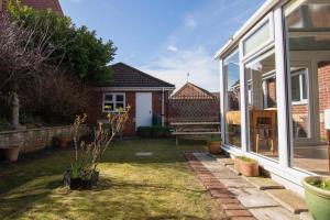 a house with a yard with a patio at Bilbo's Cottage, Sheringham in Sheringham
