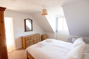 a bedroom with a white bed with towels on it at Bilbo's Cottage, Sheringham in Sheringham