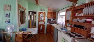 a kitchen with green walls and wooden cabinets at Sundowner 3 Bed Chalet in Hemsby Great Yarmouth in Great Yarmouth