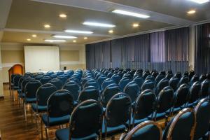 une salle de conférence vide avec des chaises et un tableau blanc dans l'établissement Hotel Coloso Potosi, à Potosí