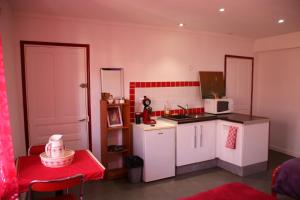 a small kitchen with white cabinets and a stove top oven at Moulin Gaillard in Bédarieux