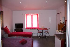 um quarto com uma cama, uma mesa e uma janela em Moulin Gaillard em Bédarieux