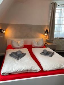 a bed with two pillows on top of it at Etna Hotel & Ristorante in Veitshöchheim