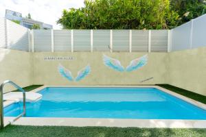 a swimming pool with wings painted on a wall at グランディオーソ沖縄プールヴィラ恩納9 in Onna