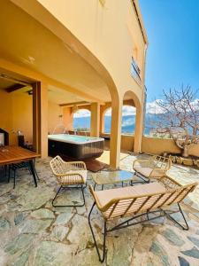 Habitación con bañera, sillas y mesa. en Authentique appartement vue montagnes avec grand patio et jacuzzi chauffé, en Santa-Reparata-di-Balagna