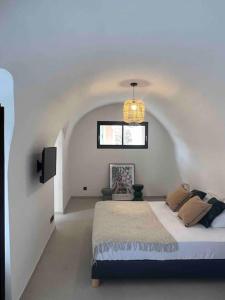 Un dormitorio blanco con una cama y un televisor. en Authentique appartement vue montagnes avec grand patio et jacuzzi chauffé, en Santa-Reparata-di-Balagna 13 fotos más