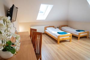 a small room with two beds and a table at Noclegi Junior Wągrowiec in Wągrowiec