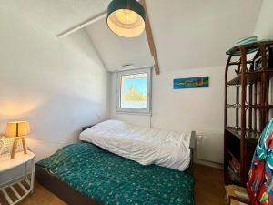 ein kleines Schlafzimmer mit einem Bett und einem Fenster in der Unterkunft Appartement Carnac, 3 pièces, 4 personnes - FR-1-377-50 in Carnac