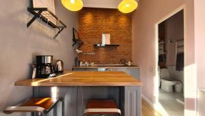 eine Küche mit einer Theke und einer Ziegelwand in der Unterkunft Republicii brick studio in Braşov