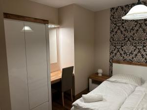 een slaapkamer met een bed, een bureau en een tafel bij Hotel Domino in Głubczyce
