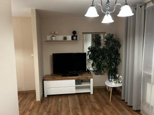 a living room with a flat screen tv on a table at Hotel Domino in Głubczyce