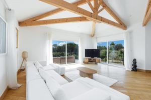 ein weißes Wohnzimmer mit einem weißen Sofa und einem TV in der Unterkunft Villa luxe - St Paul - Piscine - A/C in Saint-Paul-de-Vence