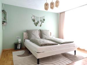 a bedroom with a white bed with a blue wall at BohèmeNest Terminal Apartments - Chic & gemütlich mit Terrasse in Waldenbuch