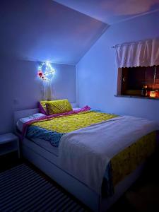 - une chambre avec un lit éclairé dans l'établissement Vineyard Cottage Planinc, à Črnomelj