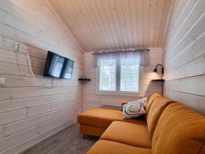 a living room with a couch and a tv at Holiday Resort Harjun Portti in Punkaharju