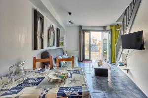 a dining room with a table and a tv at Ethoucky - Maison à 300m de la plage in Bernières-sur-Mer