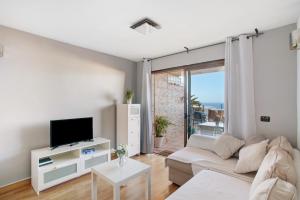 a living room with a couch and a tv at Sunset Apartment in Puerto Rico de Gran Canaria