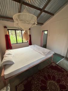 a bedroom with a bed with a chandelier above it at Nanu's Bardiya Homestay in Bhurkīā