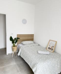 a white bedroom with two beds and a plant at Hostal Cisne in San Antonio