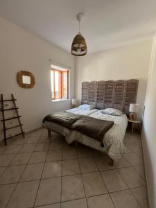 a bedroom with a bed with a wooden headboard at Maison Zen et Cosy avec Bulle pour dormir à la belle étoile & Jacuzzi in Vif