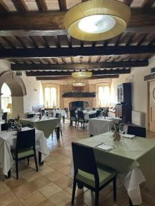 a restaurant with white tables and chairs and a fireplace at Molino Del Duca Cesi in Terni