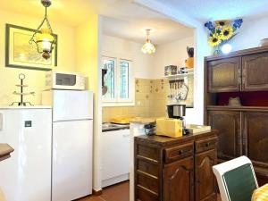 uma cozinha com um frigorífico branco e armários de madeira em Maison Le Lavandou, 4 pièces, 6 personnes - FR-1-251-567 em Le Lavandou
