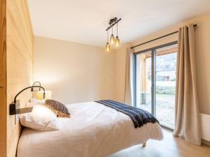 a bedroom with a bed and a large window at Maison Loudenvielle, 4 pièces, 8 personnes - FR-1-695-47 in Loudenvielle