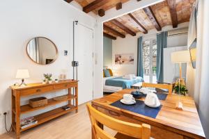 a living room with a dining room table and a bedroom at Lodging Apartments Beach Studio P1 in Barcelona