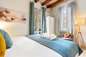 a bedroom with a bed with towels on it at Lodging Apartments Beach Studio P1 in Barcelona