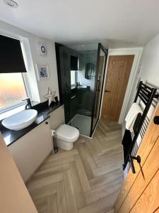 a bathroom with a toilet and a glass shower at Saffron Cottage - Modern, central, seaside, 1Bed in Hornsea