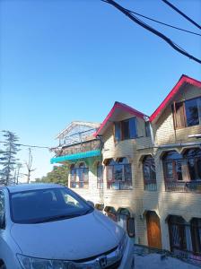 a car parked in front of a building at Hotel Rajat in Shimla