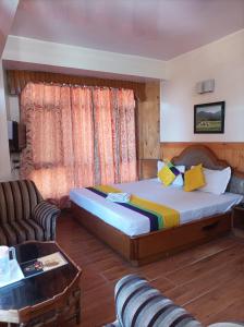 a hotel room with a bed and a couch at Hotel Rajat in Shimla
