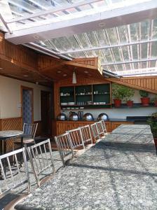 a row of chairs in a patio with a glass ceiling at Hotel Rajat in Shimla