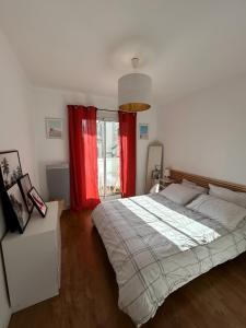 um quarto com uma cama grande e cortinas vermelhas em Appartement Unique - Roucas Blanc em Marselha