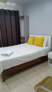 1 cama grande con 2 almohadas amarillas. en RentvistaVerde, en Tarapoto